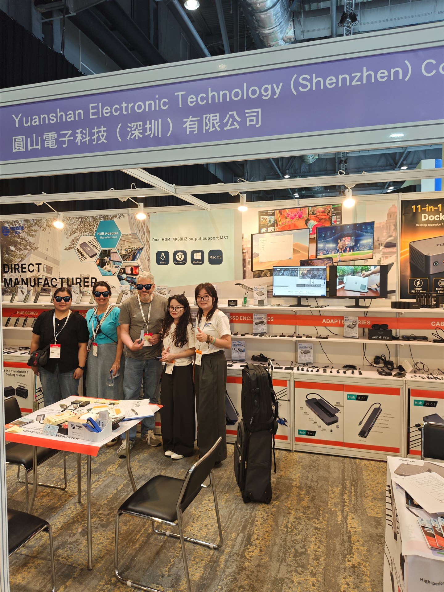 A group photo in front of the connectivity product display at the Yuanshan booth